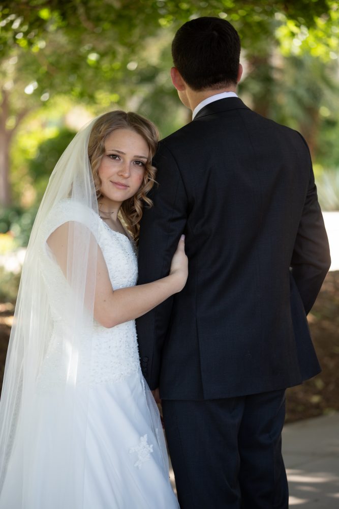 Bride looking at camera, groom looking away at the Gilbert Temple