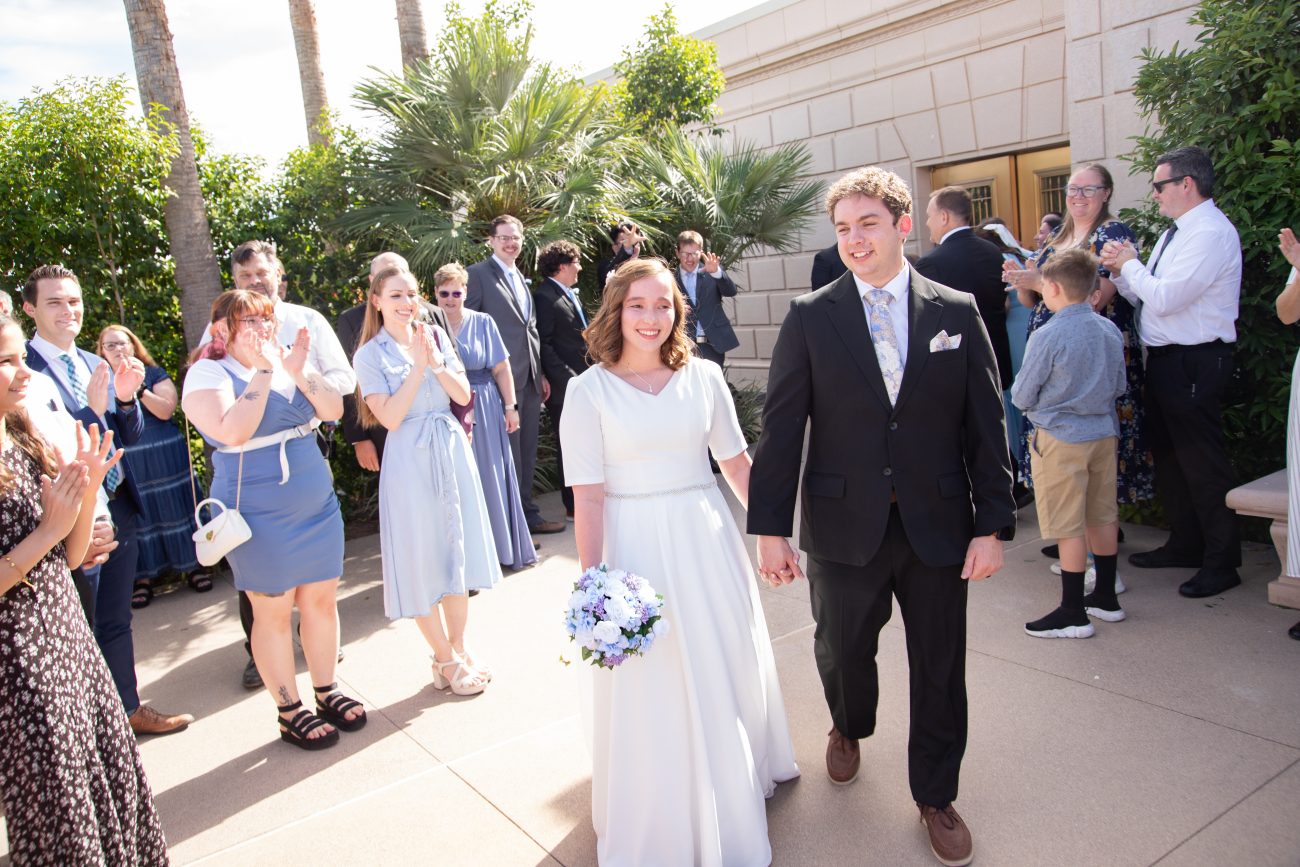Bride and groom walk amongst family at the Mesa Arizona Temple