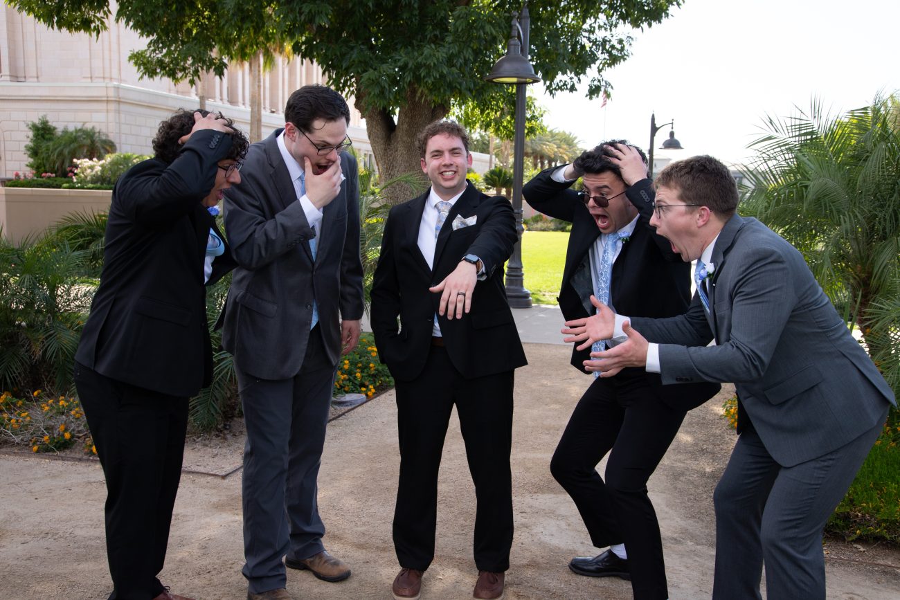 Groomsmen acting surprised while looking at the grooms ring at the Mesa Arizona Temple.