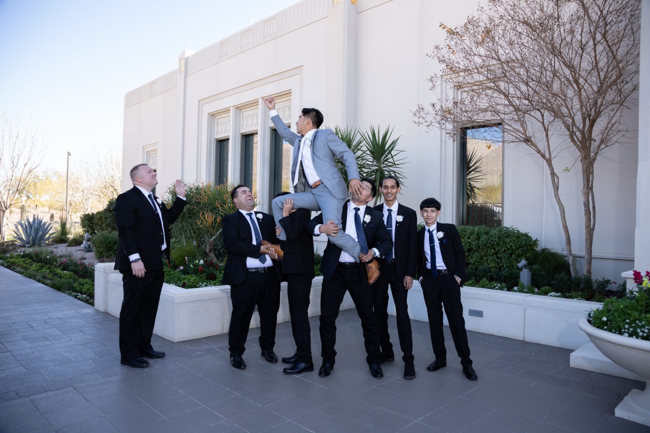 Groom being held up by his groomsmen in a Heisman Trophy post at the Tucson Arizona Temple