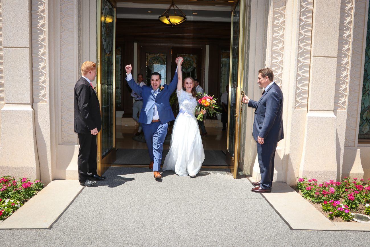 Groom and bride cheer as they exit the Gilbert Arizona temple after the wedding.