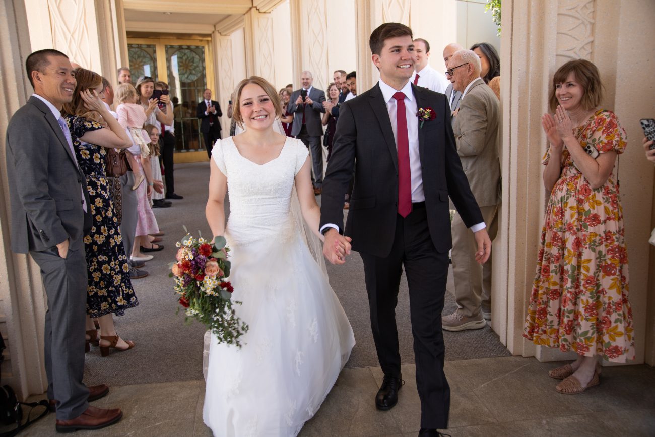 Bride and groom smile as they greet family after the wedding