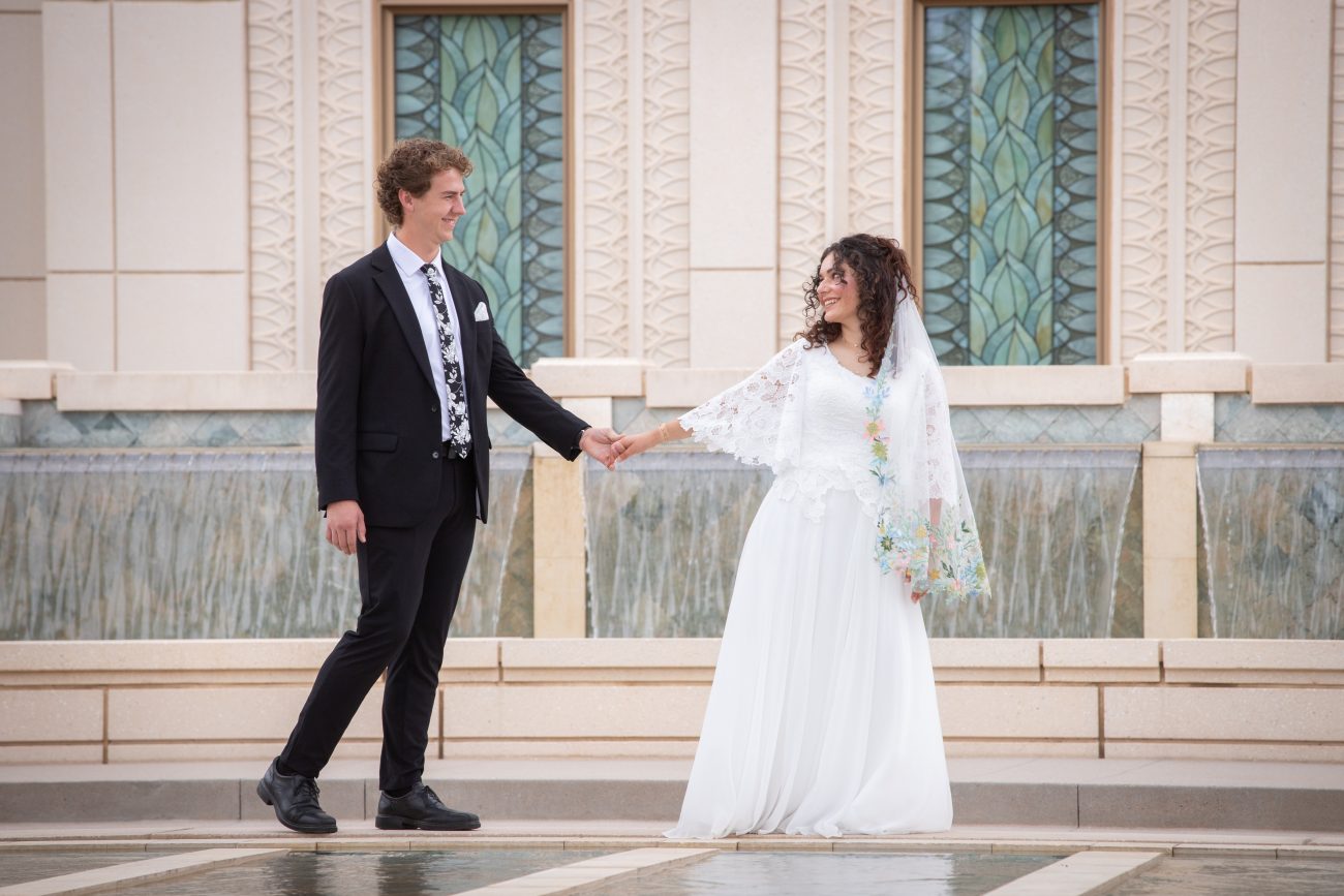 Bride leading the groom while walking on the waterfall at the Gilbert Arizona Temple