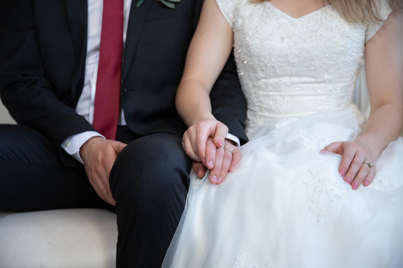 Bride and groom holding hands at LDS Wedding reception