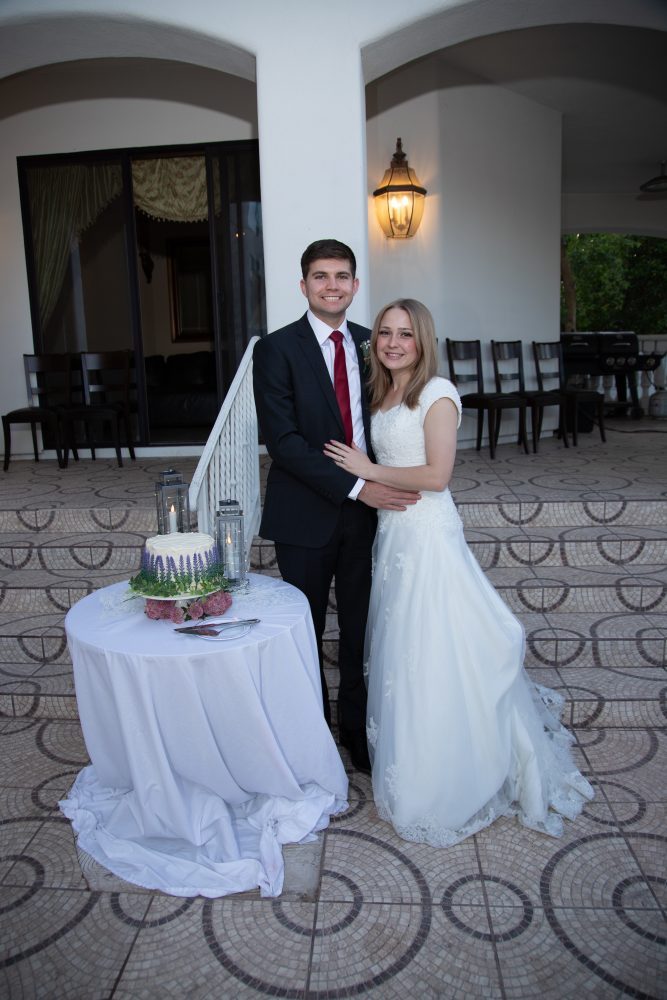 Bride and groom portrait with their wedding cake