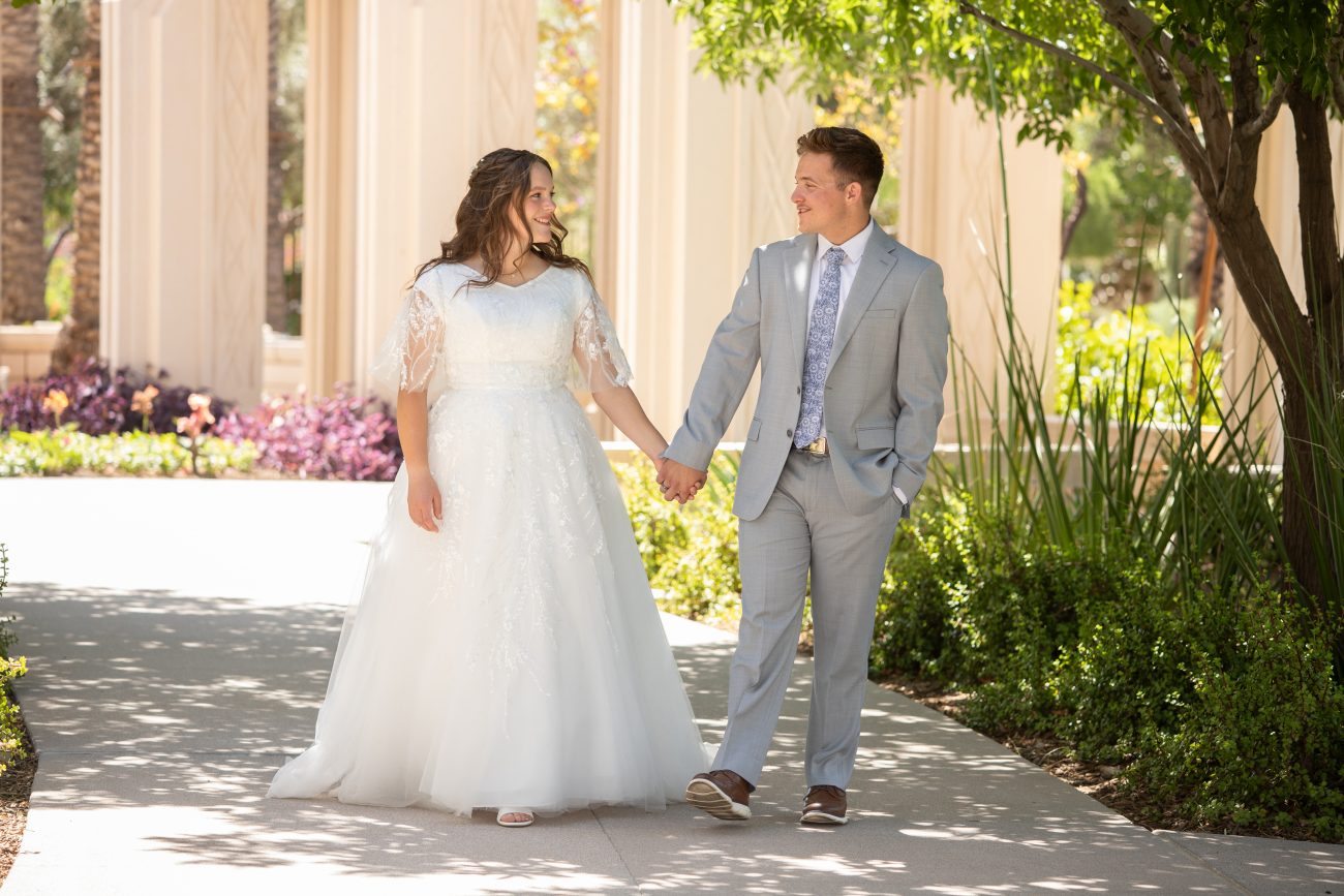 Gilbert Temple wedding with a bride and groom walking and holding hands.
